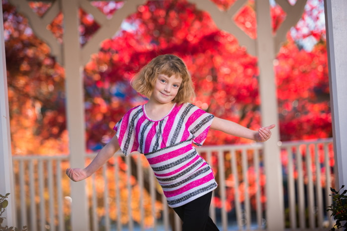 Father and daughter sharing a sweet, smiling moment during a family portrait session.