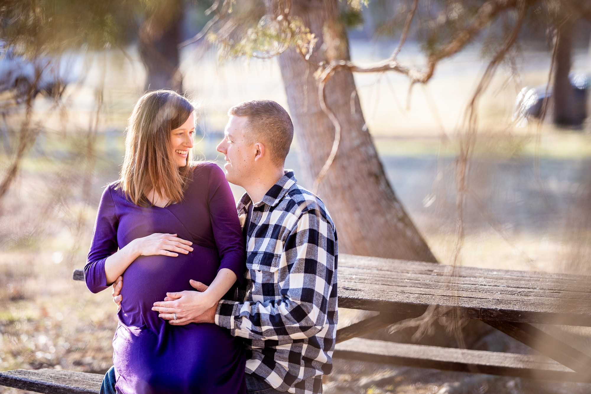 Radiant pregnant woman cradles her blossoming baby bump by the lake
