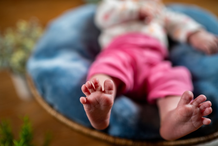 Newborn baby with feet sticking out.