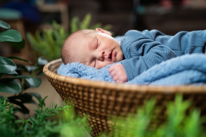 Newborn baby sleeping peacefully in a home nursery.