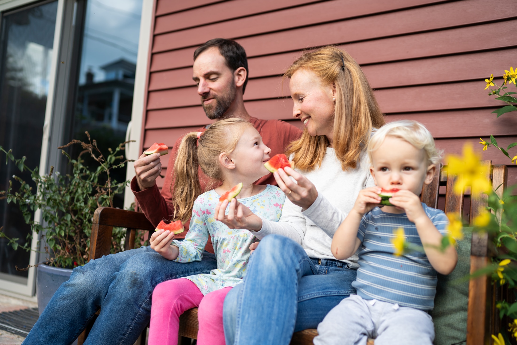 A family enjoying a watermelon picnic during their summer photo session.