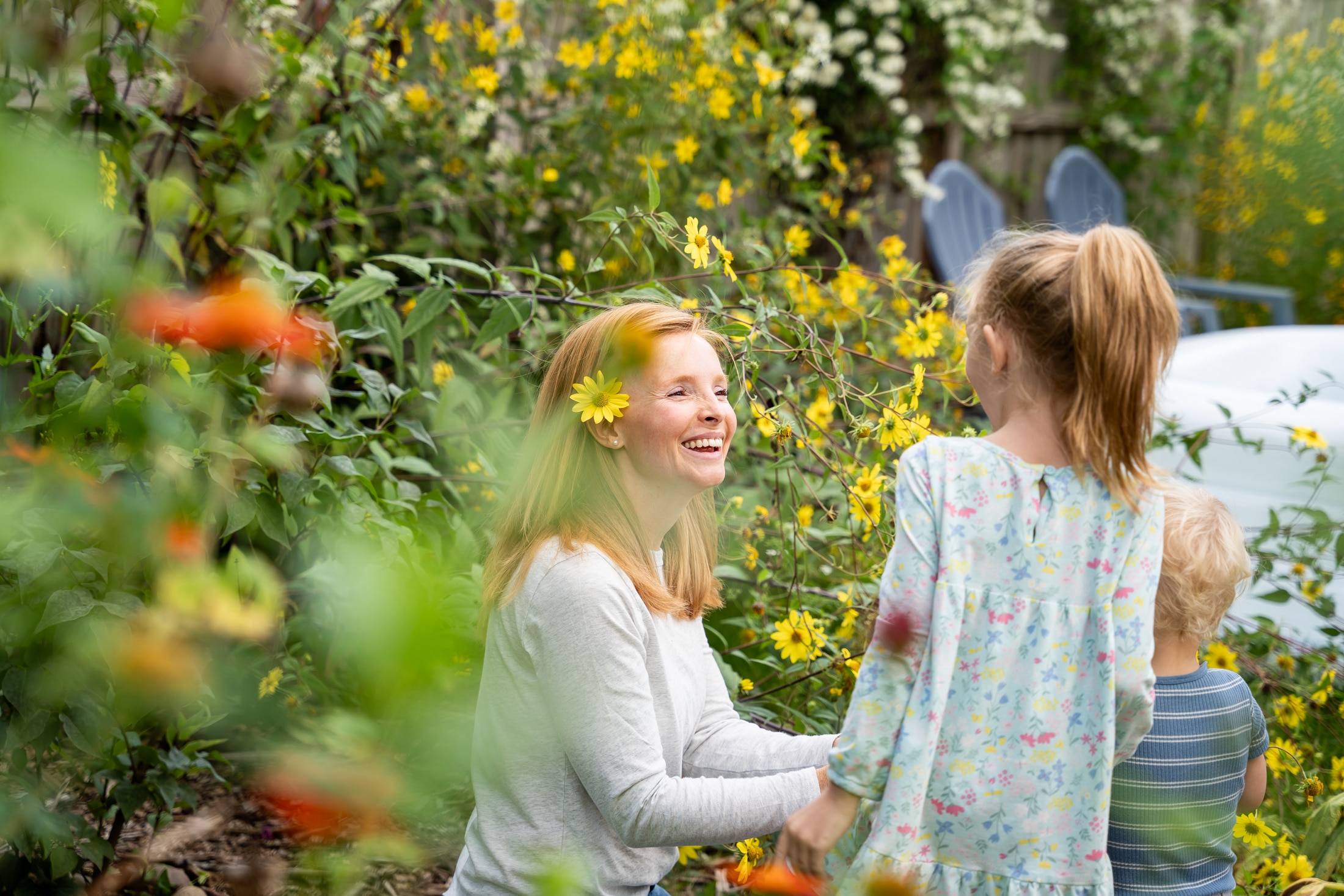 Flower power: Jancey's little girl adorning her parents with backyard blooms, the epitome of family fun.