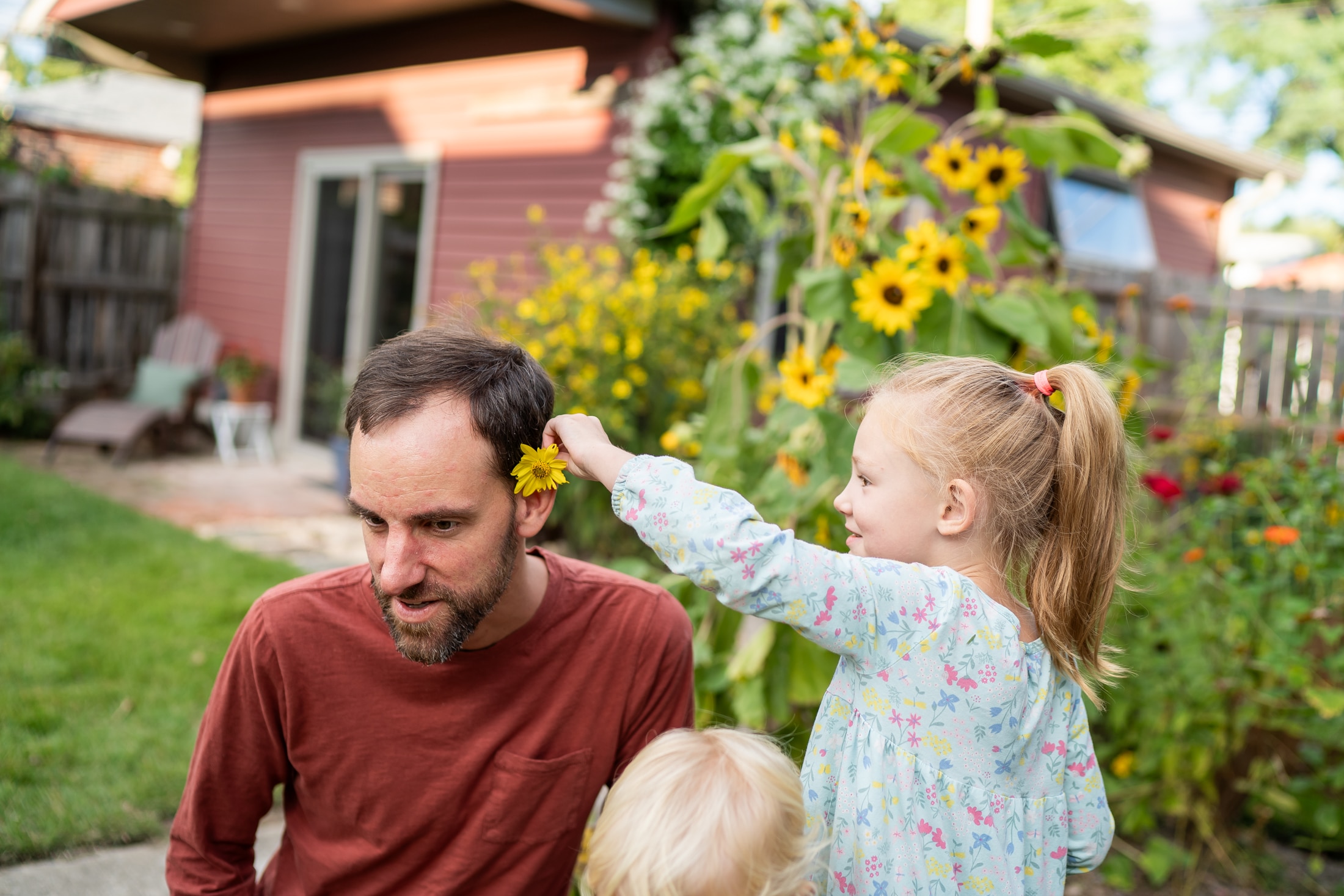 Flower power: Jancey's little girl adorning her parents with backyard blooms, the epitome of family fun.